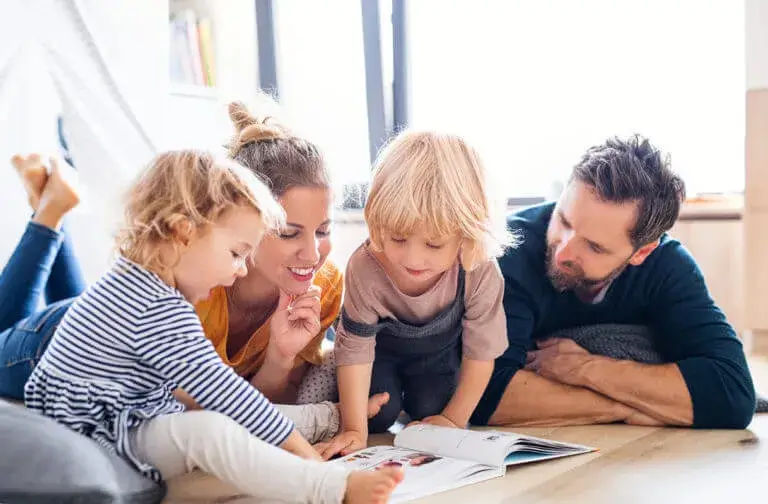 mother, father and two kids reading a book